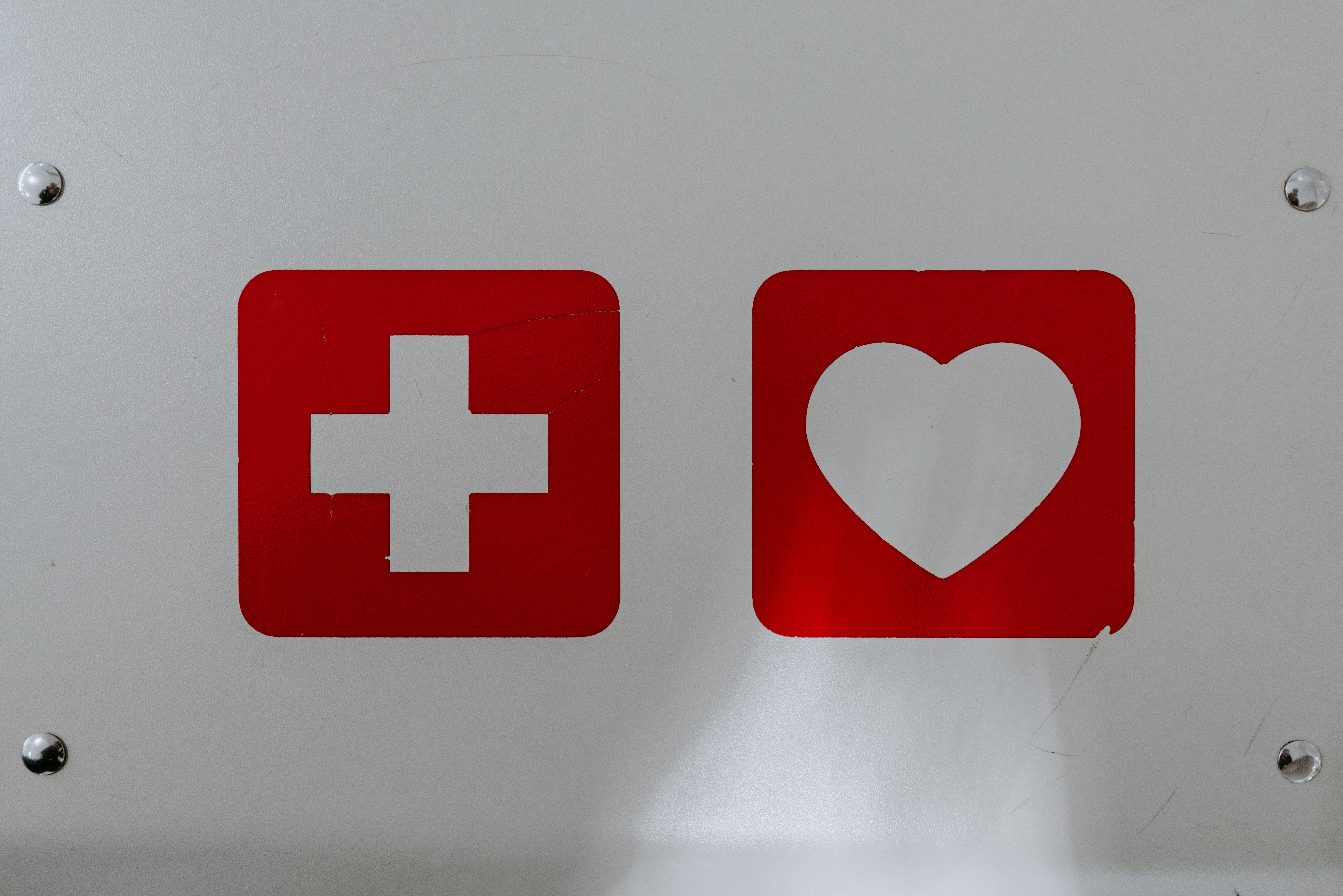 Placa de metal com uma cruz médica e um coração