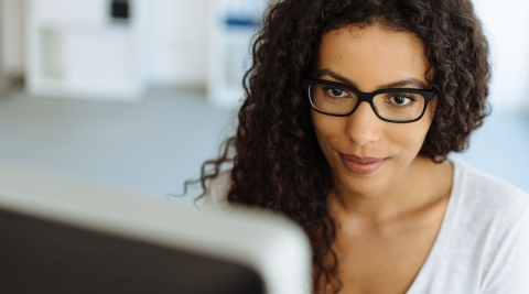 mulher negra de óculos no computador