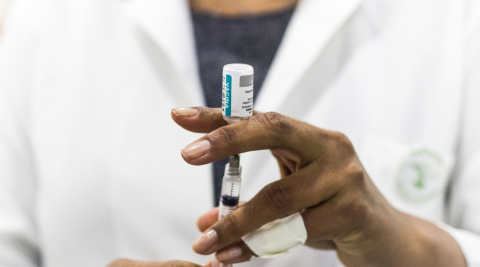 Enfermeira aspira para a seringa o conteúdo da ampola da vacina